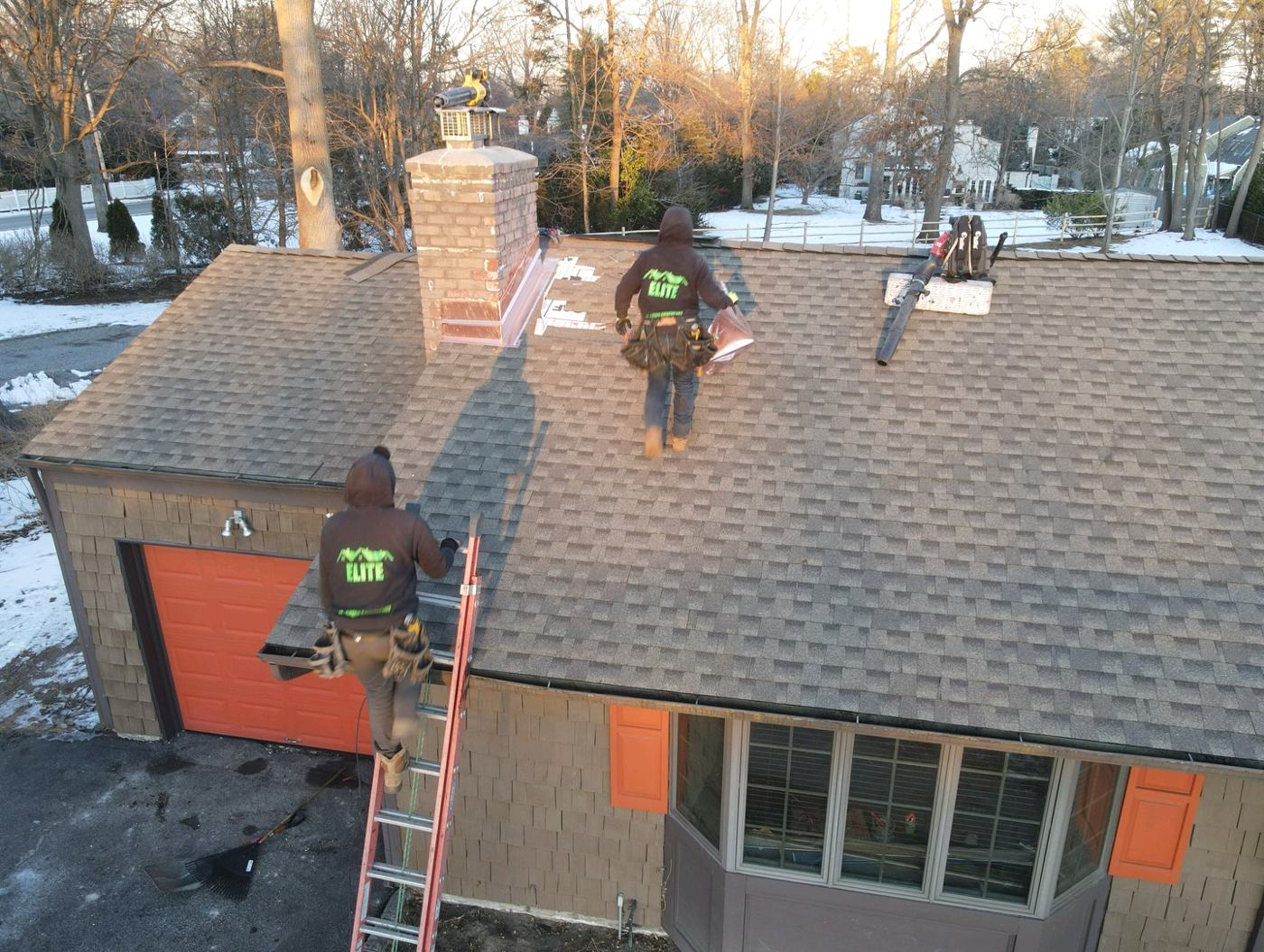 Roofing crew installing shingles around a chimney